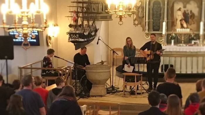 En koncert i kirke med publikum og musikere på scene