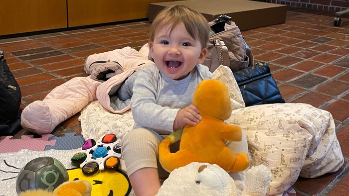 Baby sidder med bamse på et tæppe i Hundige Kirke.