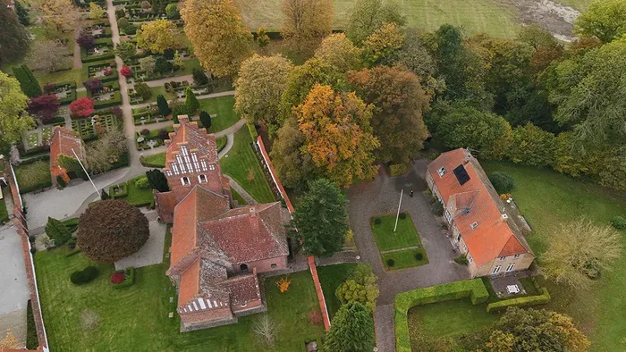 Luftfoto af Esbønderup Kirke og omkringliggende bygninger om efteråret