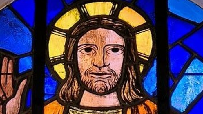 Glassmaleri af Jesus med bog og halo.