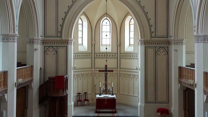 Großzügige Kirche mit hohen Bögen und Stufen zum Altar.