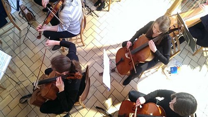 En gruppe musikanere spiller i en hal