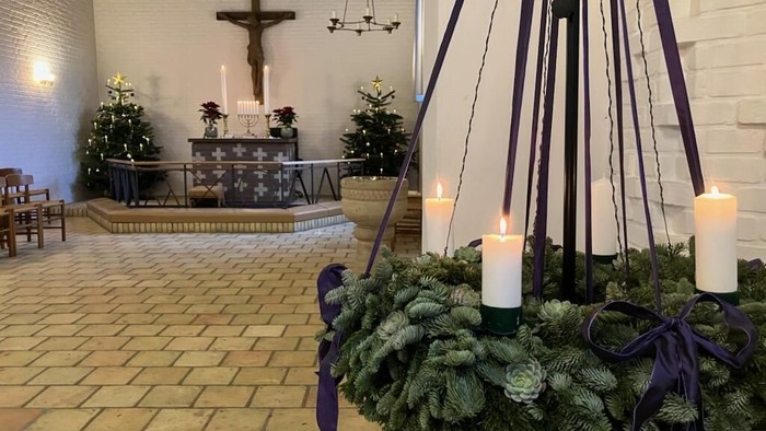 Elegant kirkealter pyntet med stedsegrønne krans, lys og festlige dekorationer i juletiden.