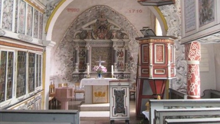 Die Kirche hat einen schönen Altar und hohe Decken.