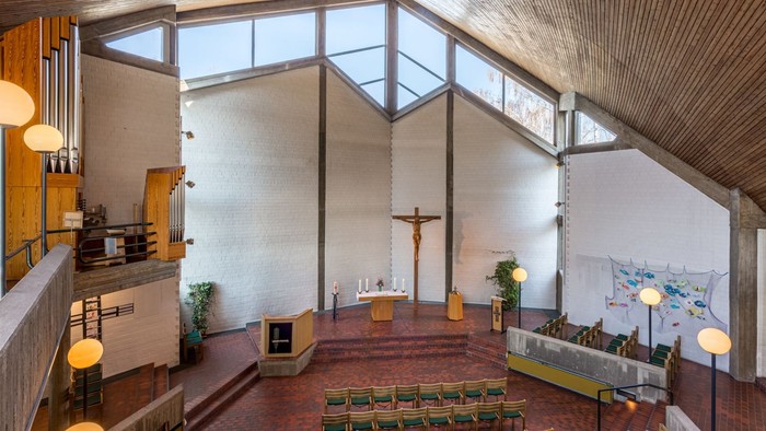 Grosse Kirche mit hohem Gewoelbe und Holzdecken, mit grossen Fenstern und Kirchenbänken