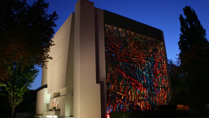 Das leuchtende bunte Kirchenfenster der Dornbuschkirche bei Nacht