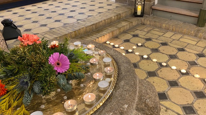 En smuk og indretning med blomster og lys på en marmorplade i en træderne.