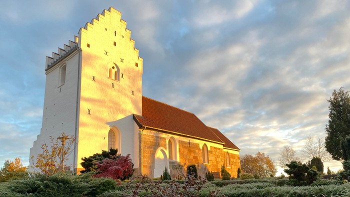 Frostklar morgen på en kirkegård foran en hvid kirke.