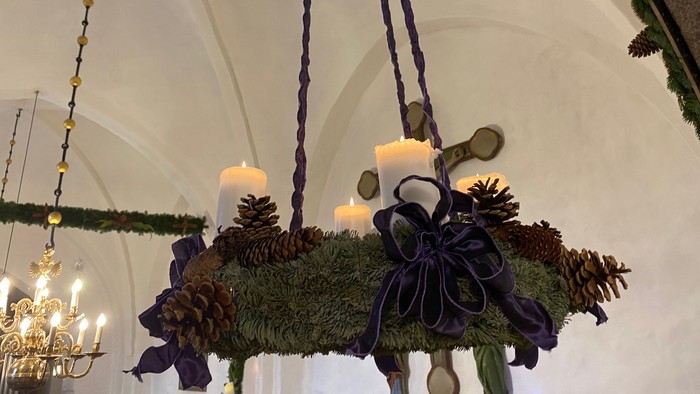 En adventskrans i gran med fire tændte lys
