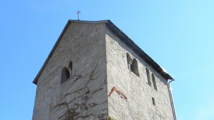 Hoher Steinturm mit Efeu, der daran wächst.