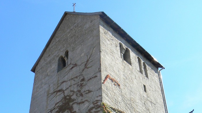Hoher Steinturm mit Efeu, der daran wächst.