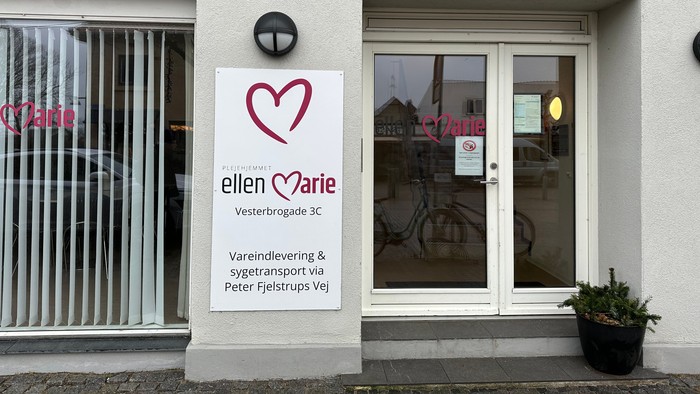 Forretning med hjerteemotikon og plant i pot på træde.