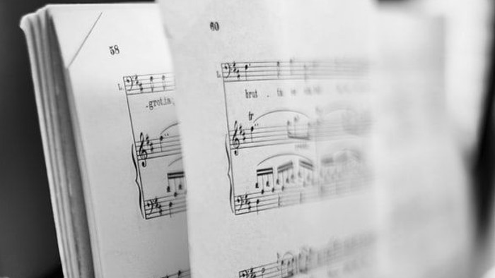 Ein Notenblatt mit Musiknoten und einem Stift.