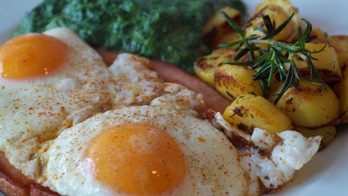 Das Bild zeigt ein Frühstücksgericht mit Spiegelei, Kartoffeln und Spinat