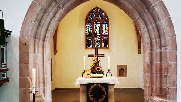 Gotteshaus mit Altar und Buntglasfenster