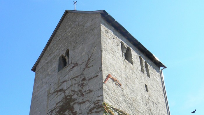 Hoher Steinturm mit Efeu, der daran wächst.
