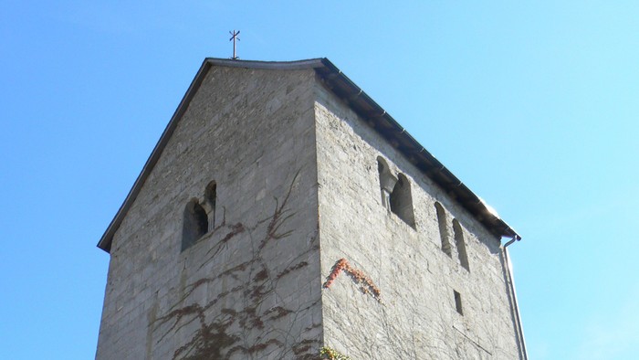 Hoher Steinturm mit Efeu, der daran wächst.
