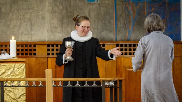 En præst holder en kælenav i kirke.