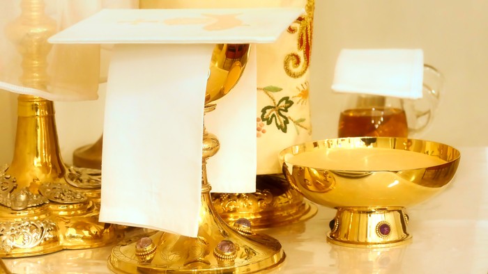 Elegante goldene Tischdekoration mit einer weißen Karte und einer verzierten Teekanne auf einer Marmoroberfläche.