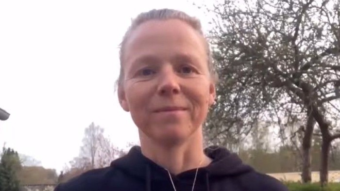 Mette står udenfor med træ i baggrunden.