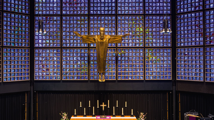 Die Kirche hat ein farbiges Glasfenster und eine goldene Jesus-Statue.