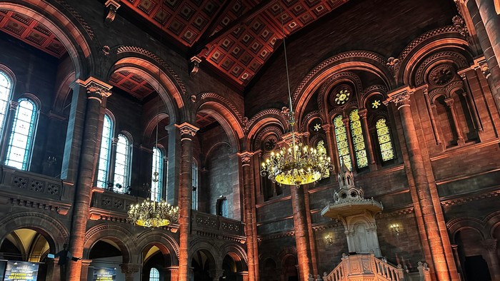 Intérieur d'une église avec des gens assis et des lustres