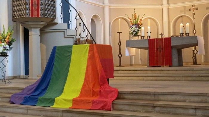 Bunte Flagge liegt auf Kirchenstufen vor Kanzel