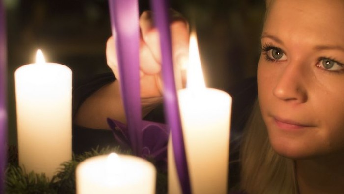 En ung pige ser træt ud mellem lysende lysstaker og violette bælter.