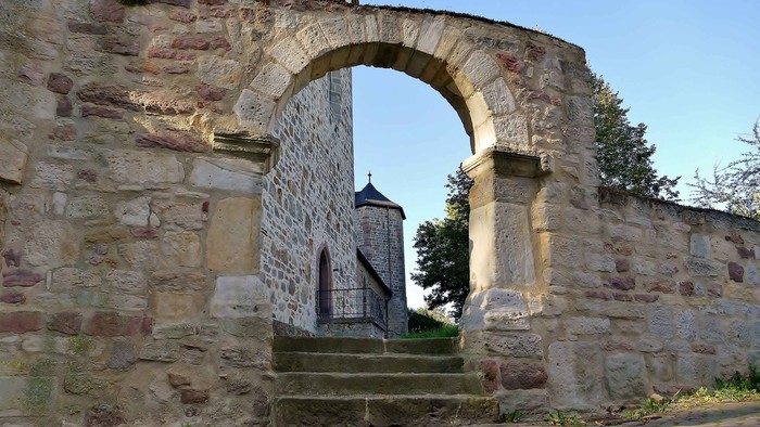 Das Foto zeigt den Torbogen, durch den man geht, wenn man vom Tal aus zur Stiftskirche Kaufungen kommt.