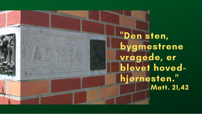 En sten med indgraveret citat fra Matthæus 21,42 på en mur.