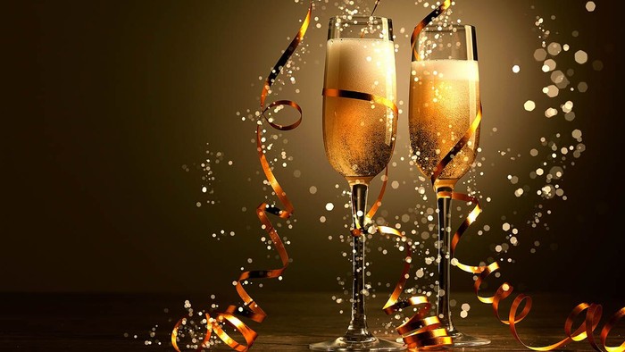 To guldglitrende champagneglas med bælter og konfetti