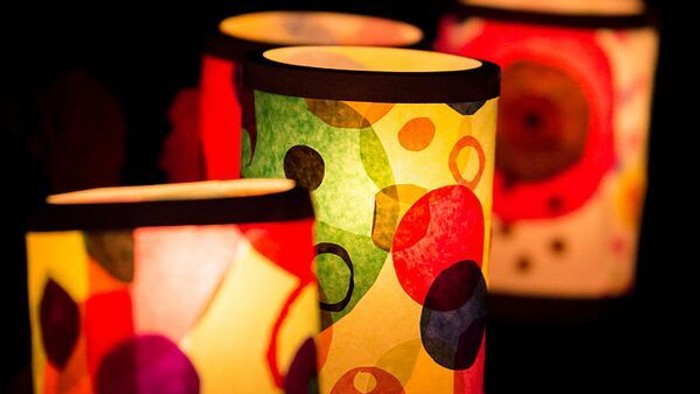 Drei bunte Lichter mit kreisförmigen Mustern leuchten im Dunkeln