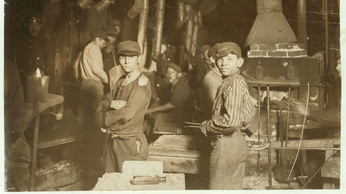 Das Foto zeigt in Sepia arbeitende Jugendliche Anfang des 20. Jahrhunderts
