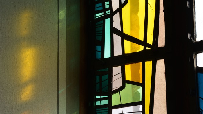 Buntes Glasfenster wirft Licht auf die Wand