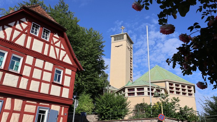 Kirche Niederursel von vorn mit Rosen