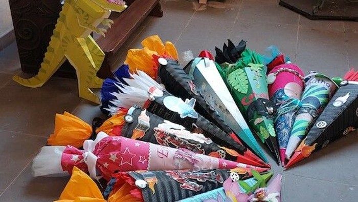 Überall im Raum verstreute Regenschirme in verschiedenen Farben und Mustern.