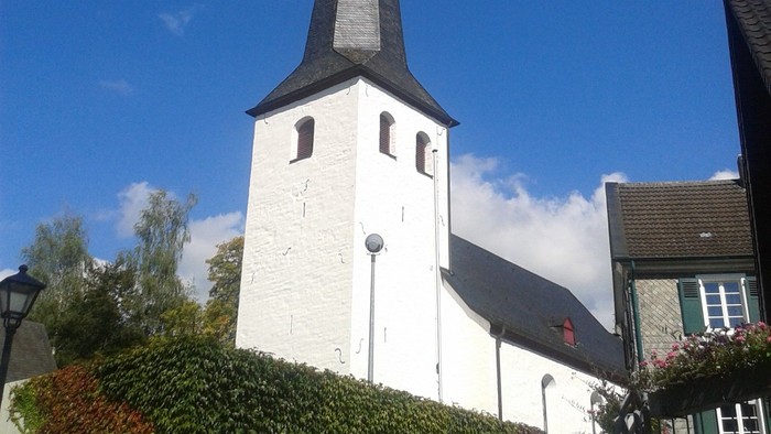 Weiße Kirche mit hohem Turm und blauen Himmel