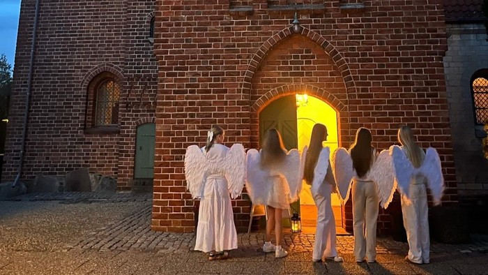 Konfirmanderne er klædt ud som engle og venter på at byde børn fra byen velkommen til Englevagt i Ishøj Kirke