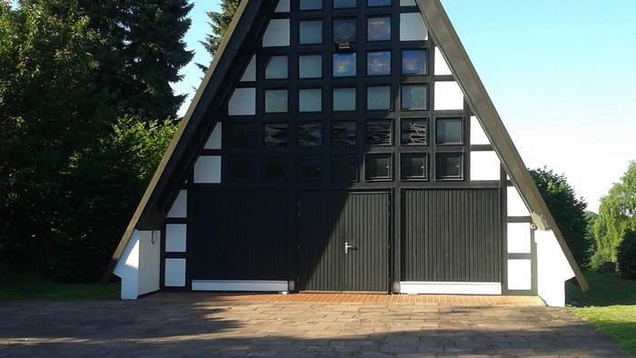 Das Bild zeigt ein dreieckiges Gebäude mit schwarzer und weißer Fassade.