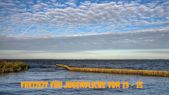 Malerische Uferlinie mit schwimmenden Stegen unter einem teilweise bewölkten Himmel, auf Deutsch beschriftet mit „kostenloses Parken von 19 bis 21 Uhr“.