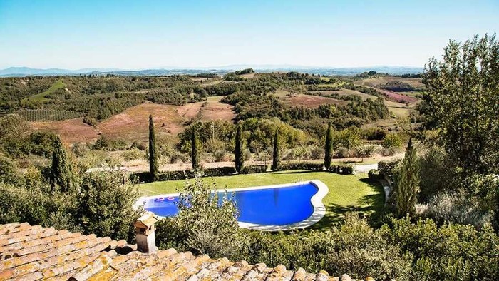 Atemberaubende Aussicht auf eine üppige Landschaft mit einem ruhigen Infinity-Pool, umgeben von Grün und sanften Hügeln.