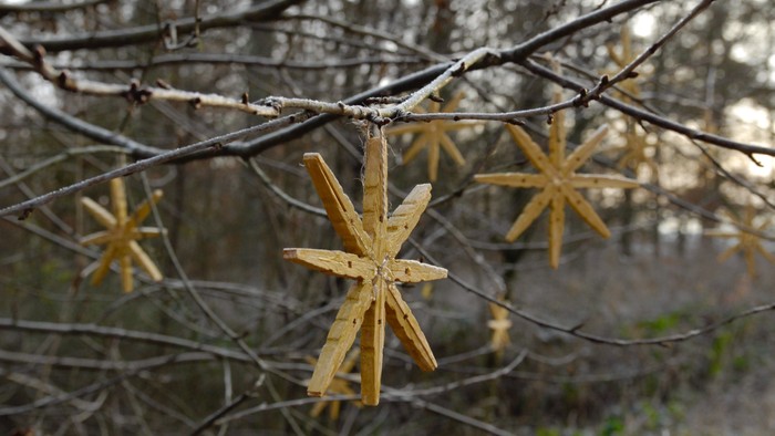 Holzsterne hängen an einem Zaun im Freien