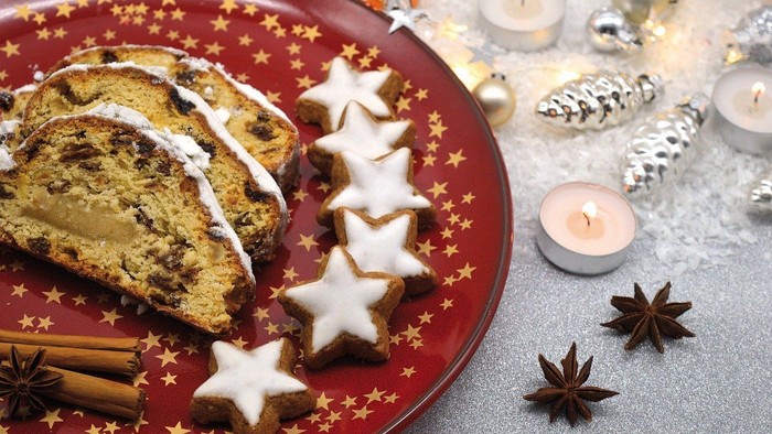 Weihnachtlicher Teller mit Stollen und Sternengebäck, Kerzen und Gewürzen