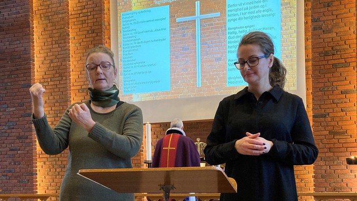 To women står ved pulpet i kirke