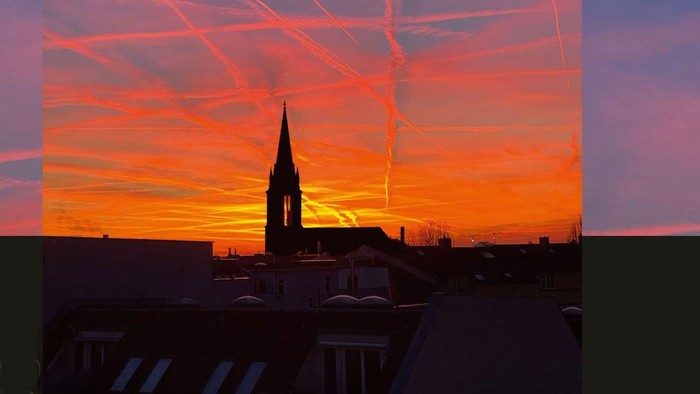 Bunter Sonnenuntergang über Stadt mit Kirche, Text 