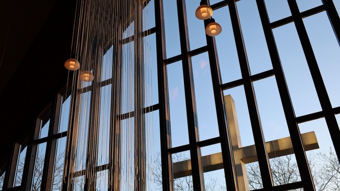 Moderne bygning med store glasvinduer og hængende lamper.