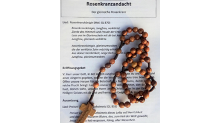 Hölzerner Rosenkranz auf Lied- und Andachtt-Textblatt