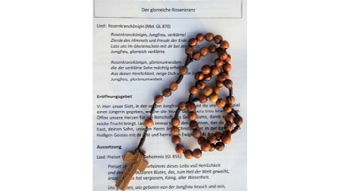 Hölzerner Rosenkranz auf Lied- und Andachtt-Textblatt
