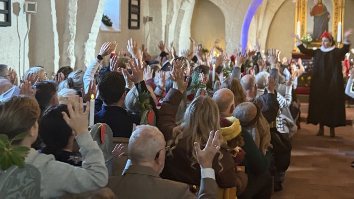 Alle sidder klar på kirkebænkene med spredte fingre for at bede en bøn til familiegudstjeneste d. 24. december i Ishøj Kirke