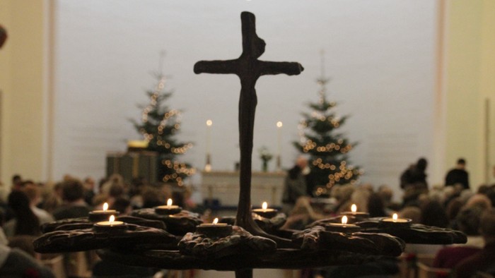 Lysgloben i Vejleå Kirke er tændt og juletræerne ses svagt i baggrunden.